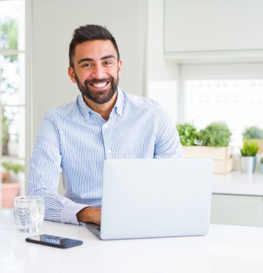 A smiling person sitting with laptop searching about best software development company in Canada